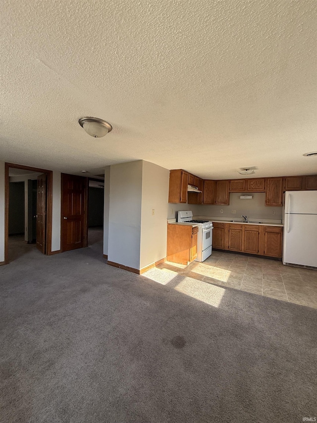 1406 N Philips St, Kokomo, IN 46901 - kitchen with white appliances, a sink, a textured ceiling, light countertops, and brown cabinetry