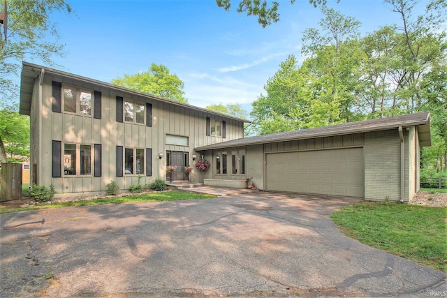 54559 Whispering Oak Dr, Mishawaka, IN 46545 - view of front facade featuring board and batten siding, an attached garage, brick siding, and asphalt driveway