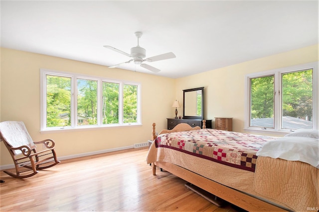 54559 Whispering Oak Dr, Mishawaka, IN 46545 - bedroom featuring multiple windows, light wood-type flooring, baseboards, and a ceiling fan