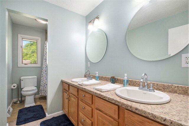 54559 Whispering Oak Dr, Mishawaka, IN 46545 - full bathroom featuring double vanity, toilet, and tile patterned floors