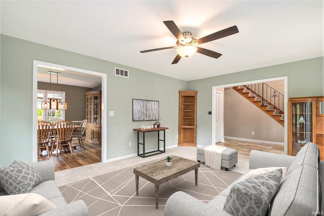 54559 Whispering Oak Dr, Mishawaka, IN 46545 - living room with stairs, ceiling fan, a chandelier, and baseboards