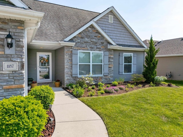 1187 Gateway Trl, Fort Wayne, IN 46845 - entrance to property featuring stone siding, a yard, and a shingled roof