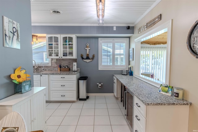 11382 N Biscayne Ln, Cromwell, IN 46732 - kitchen featuring glass insert cabinets, white cabinets, light tile patterned floors, baseboards, and crown molding