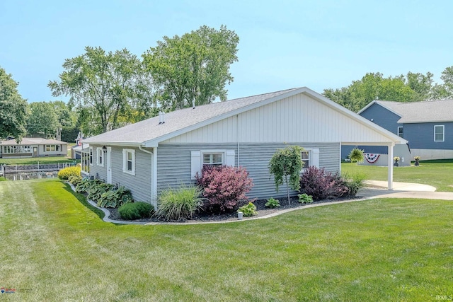11382 N Biscayne Ln, Cromwell, IN 46732 - view of side of home with a lawn, driveway, an attached carport, and roof with shingles