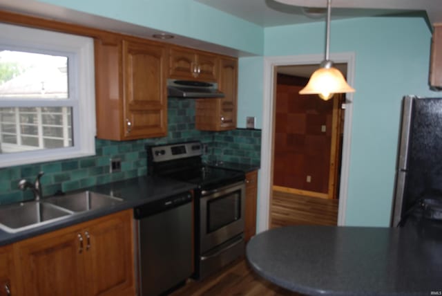 2310 Homewood Ave, Mishawaka, IN 46544 - kitchen featuring stainless steel appliances, under cabinet range hood, a sink, dark countertops, and brown cabinets