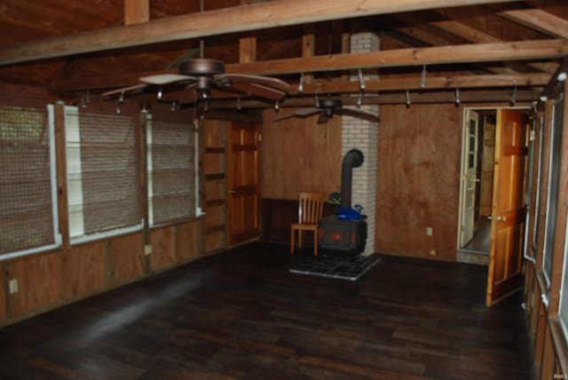 2310 Homewood Ave, Mishawaka, IN 46544 - spare room with a wood stove, ceiling fan, wood finished floors, wooden walls, and beam ceiling