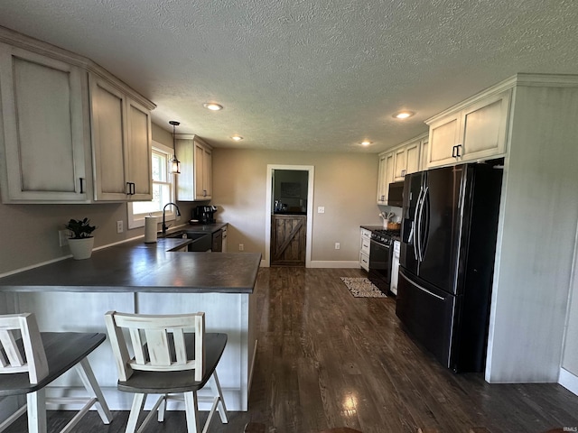 12524 W 545 N, Linton, IN 47441 - kitchen featuring black fridge with ice dispenser, dark countertops, gas range oven, a peninsula, and a textured ceiling