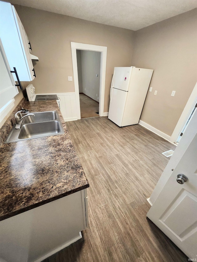 436 E Taber St, Fort Wayne, IN 46803 - kitchen featuring white appliances, a sink, wood finished floors, dark countertops, and range hood