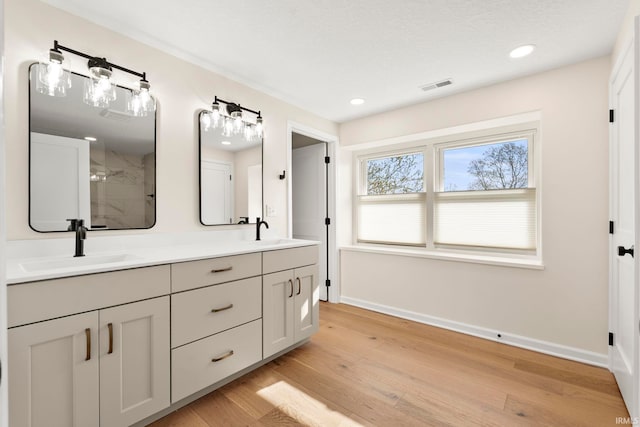11136 N 200 W, Ossian, IN 46777 - bathroom featuring double vanity, baseboards, a stall shower, wood finished floors, and recessed lighting
