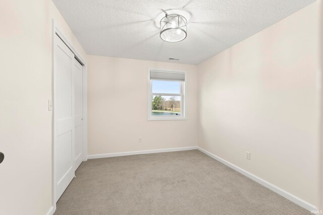 11136 N 200 W, Ossian, IN 46777 - unfurnished bedroom with a textured ceiling, carpet, baseboards, and a closet