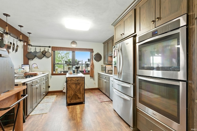 2090 S Warren Rd, Huntington, IN 46750 - kitchen featuring stainless steel appliances, light wood-type flooring, light countertops, and hanging light fixtures
