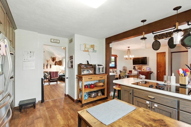 2090 S Warren Rd, Huntington, IN 46750 - kitchen featuring dark wood-style floors, a chandelier, black electric cooktop, and light countertops