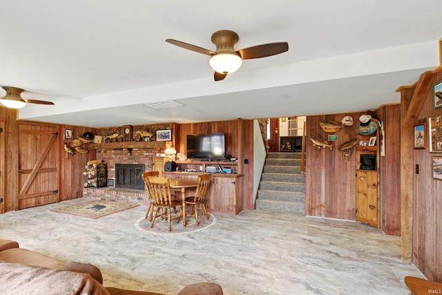 2090 S Warren Rd, Huntington, IN 46750 - living area featuring wooden walls, a ceiling fan, stairs, and a brick fireplace