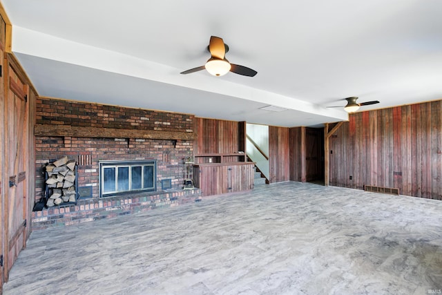 2090 S Warren Rd, Huntington, IN 46750 - unfurnished living room featuring ceiling fan, wooden walls, stairway, and a fireplace