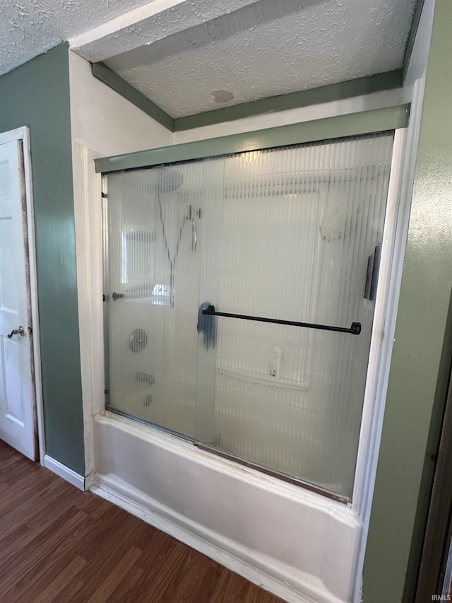14512 Old State Road 37, Tell City, IN 47586 - full bathroom with wood finished floors, bath / shower combo with glass door, a textured ceiling, and baseboards