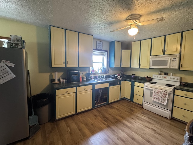 14512 Old State Road 37, Tell City, IN 47586 - kitchen featuring white appliances, dark countertops, a sink, wood finished floors, and a ceiling fan