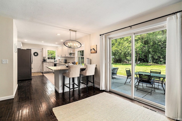 58201 Windsong Dr, Elkhart, IN 46517 - kitchen with freestanding refrigerator, white cabinetry, a peninsula, a breakfast bar, and baseboards