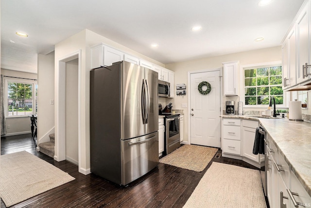 58201 Windsong Dr, Elkhart, IN 46517 - kitchen featuring appliances with stainless steel finishes, a sink, white cabinets, baseboards, and recessed lighting