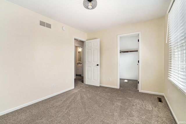 58201 Windsong Dr, Elkhart, IN 46517 - unfurnished bedroom featuring carpet floors, a walk in closet, baseboards, and a closet