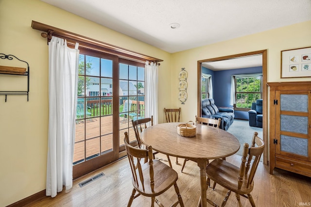 61587 Brompton Rd, South Bend, IN 46614 - dining space with light wood-type flooring, a textured ceiling, and baseboards