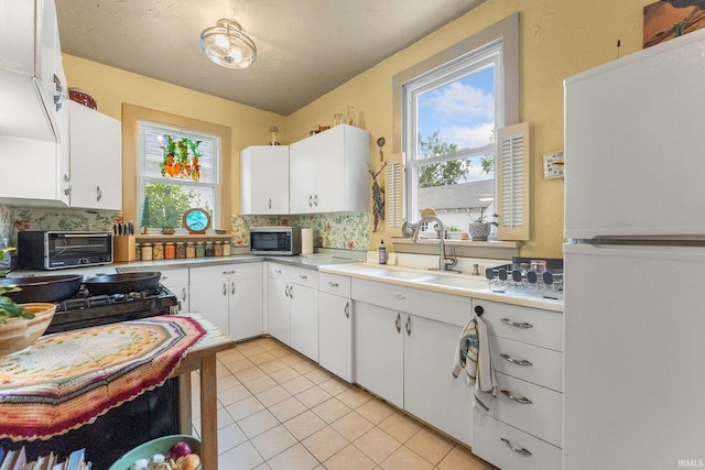 1712 High St, Fort Wayne, IN 46808 - kitchen featuring freestanding refrigerator, a sink, plenty of natural light, and light tile patterned floors