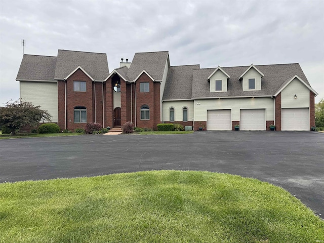 5533 N 150 Rd E, Urbana, IN 46990 - townhome / multi-family property with brick siding, asphalt driveway, a front lawn, a chimney, and a shingled roof