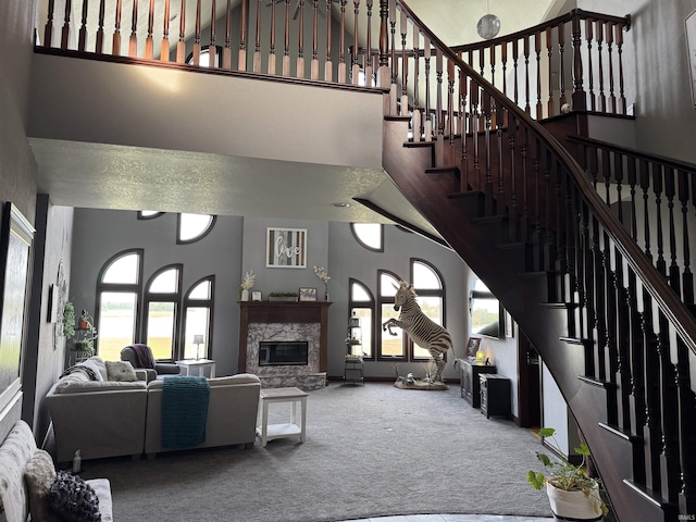 5533 N 150 Rd E, Urbana, IN 46990 - carpeted living area featuring a towering ceiling, a fireplace, and stairway