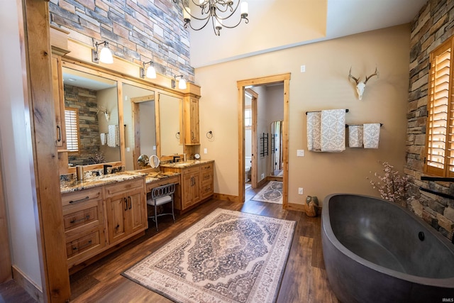 8615 W 450 S, Hudson, IN 46747 - bathroom featuring a freestanding bath, wood finished floors, double vanity, a chandelier, and baseboards
