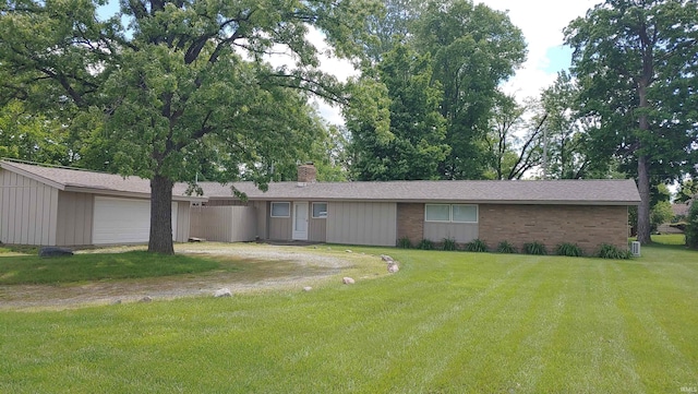 217 W Washington Center Rd, Fort Wayne, IN 46825 - view of front of house with dirt driveway, a chimney, a front lawn, a garage, and brick siding
