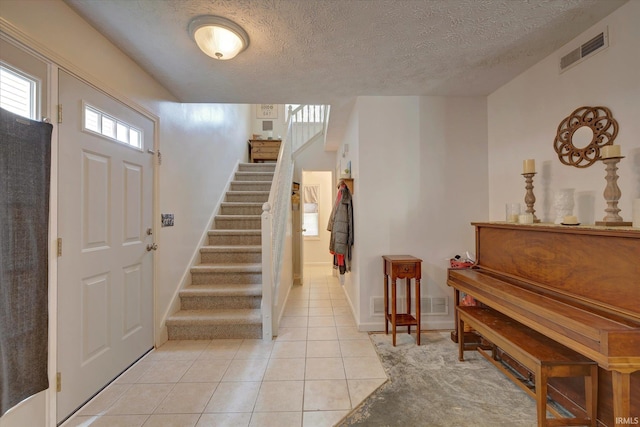 2881 S Walnut St Pike, Bloomington, IN 47401 - foyer featuring stairs, a textured ceiling, light tile patterned floors, and baseboards