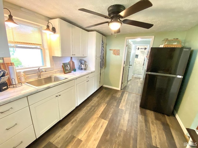 138 N Harrison St, Bloomfield, IN 47424 - kitchen with freestanding refrigerator, a textured ceiling, a sink, white cabinets, and light countertops