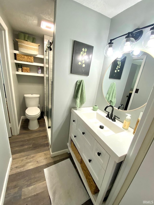 138 N Harrison St, Bloomfield, IN 47424 - full bathroom featuring toilet, a textured ceiling, vanity, wood finished floors, and a shower stall