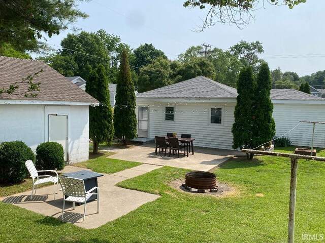 138 N Harrison St, Bloomfield, IN 47424 - rear view of house with a fire pit, a patio area, and a lawn
