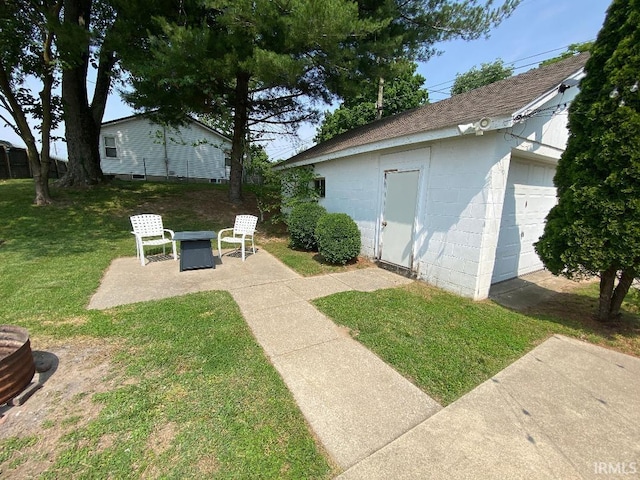138 N Harrison St, Bloomfield, IN 47424 - view of green lawn featuring an outbuilding, a garage, and a patio