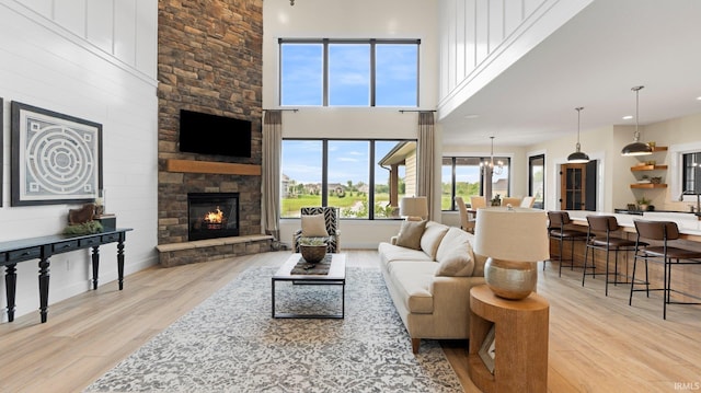5272 Greyson Heights Dr, Auburn, IN 46706 - living room featuring light wood finished floors, a stone fireplace, and a high ceiling