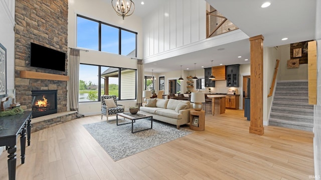 5272 Greyson Heights Dr, Auburn, IN 46706 - living area with a stone fireplace, a towering ceiling, light wood-style flooring, stairway, and recessed lighting