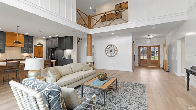 5272 Greyson Heights Dr, Auburn, IN 46706 - living area with a towering ceiling, light wood-type flooring, french doors, ornate columns, and recessed lighting