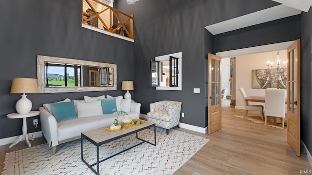 5272 Greyson Heights Dr, Auburn, IN 46706 - living room with a chandelier, wood finished floors, a towering ceiling, and baseboards