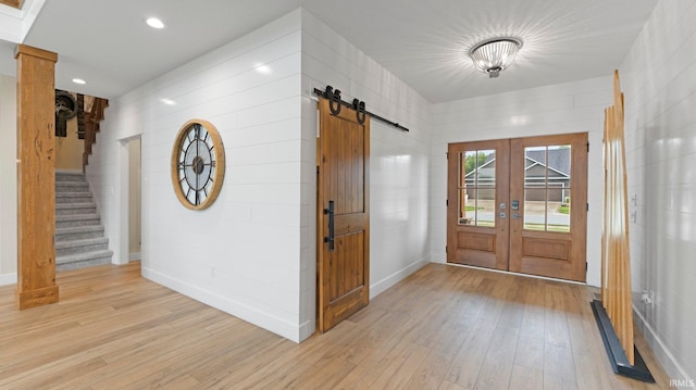 5272 Greyson Heights Dr, Auburn, IN 46706 - entryway featuring light wood-style floors, a barn door, french doors, and stairs