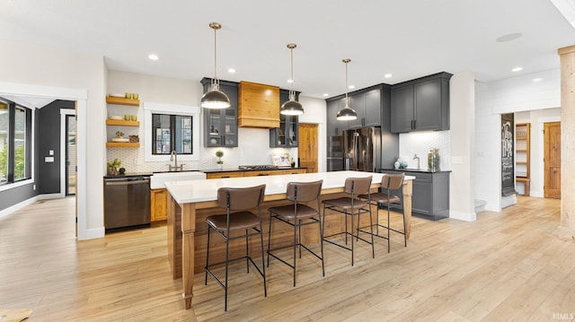 5272 Greyson Heights Dr, Auburn, IN 46706 - kitchen with dishwashing machine, stainless steel fridge, a sink, tasteful backsplash, and light wood-style flooring
