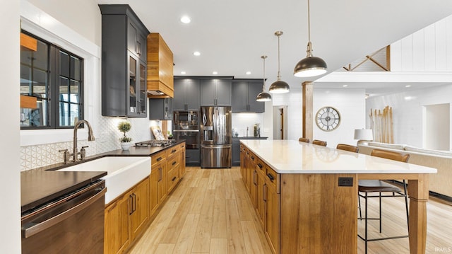 5272 Greyson Heights Dr, Auburn, IN 46706 - kitchen featuring appliances with stainless steel finishes, a breakfast bar area, a sink, light wood finished floors, and tasteful backsplash