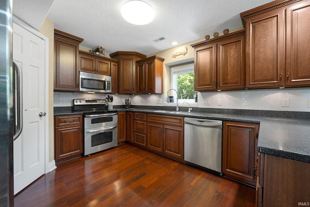 16316 Thunderbird Rd, Huntertown, IN 46748 - kitchen with stainless steel appliances, a sink, dark wood-style floors, and dark countertops