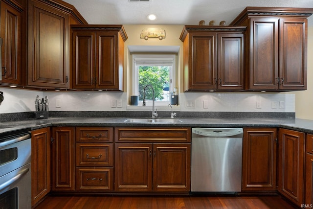 16316 Thunderbird Rd, Huntertown, IN 46748 - kitchen with dishwasher, a sink, stove, dark countertops, and dark wood-type flooring