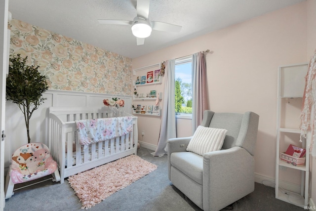 16316 Thunderbird Rd, Huntertown, IN 46748 - bedroom with a wainscoted wall, a nursery area, wallpapered walls, a ceiling fan, and carpet