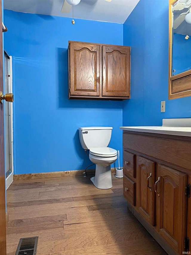 209 Acton St, Loogootee, IN 47553 - bathroom featuring wood finished floors, ceiling fan, vanity, toilet, and baseboards