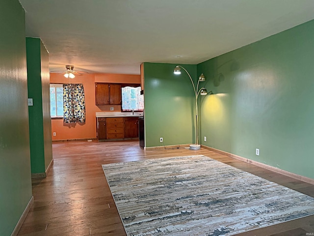 209 Acton St, Loogootee, IN 47553 - unfurnished living room with a ceiling fan, light wood-style floors, baseboards, and a sink