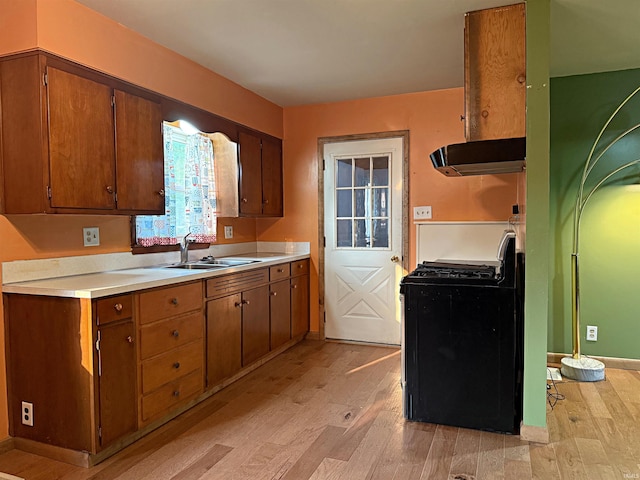 209 Acton St, Loogootee, IN 47553 - kitchen featuring black gas stove, range hood, a sink, light wood-style flooring, and light countertops