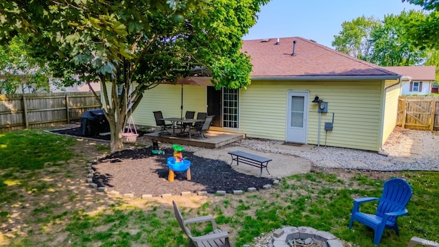 36 Jacks St, Gas City, IN 46933 - back of house featuring a fire pit, a fenced backyard, roof with shingles, a wooden deck, and outdoor dining area