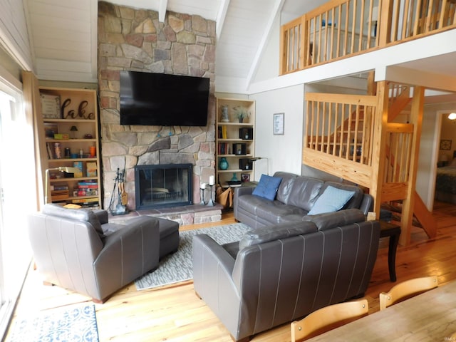 9381 E Promontory Point Dr, Syracuse, IN 46567 - living room with wood finished floors, beam ceiling, a stone fireplace, and high vaulted ceiling