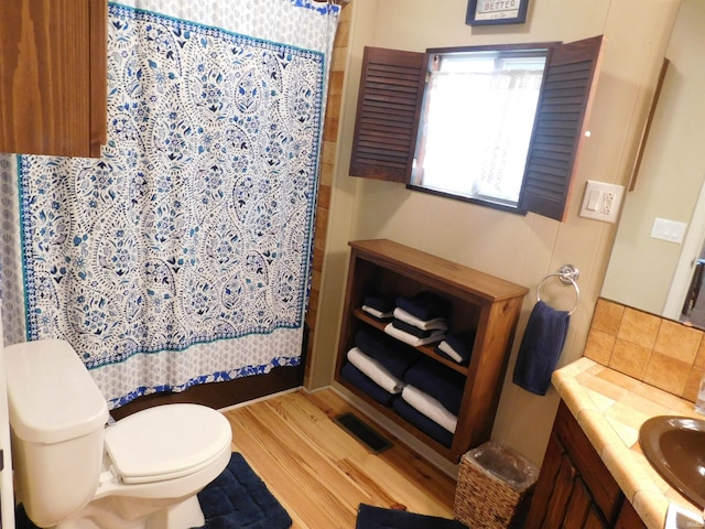 9381 E Promontory Point Dr, Syracuse, IN 46567 - bathroom featuring toilet, wood finished floors, vanity, and a shower with curtain